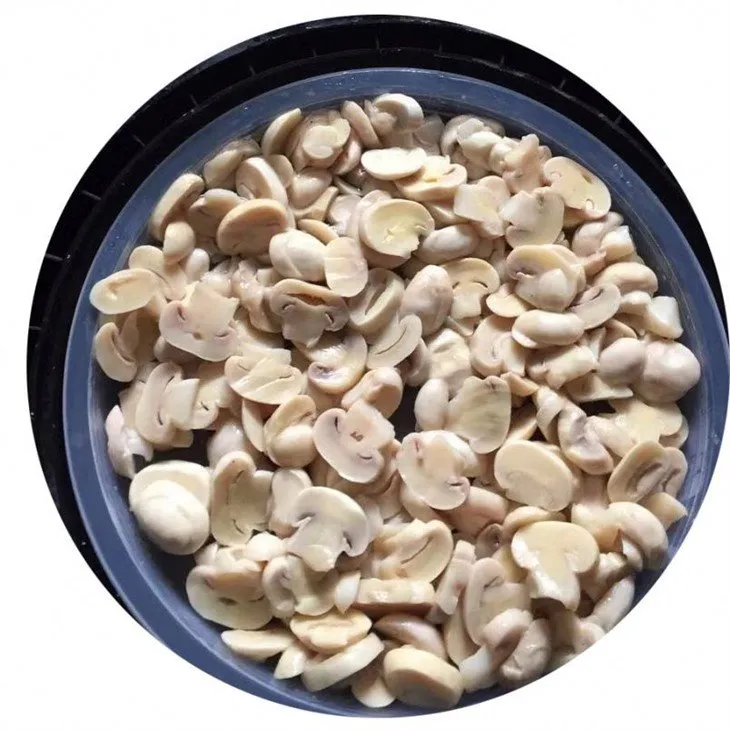 Sliced white mushroom in brine in drums