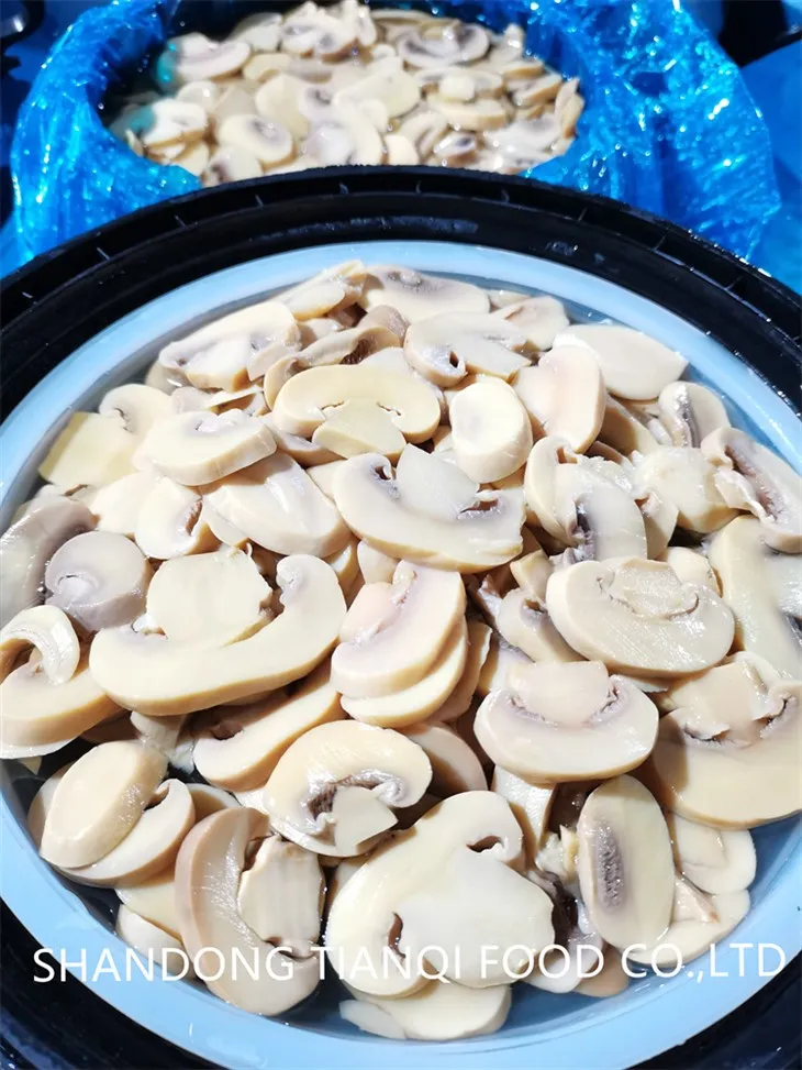 Geschnittener weißer Champignon in Salzlake in Fässern